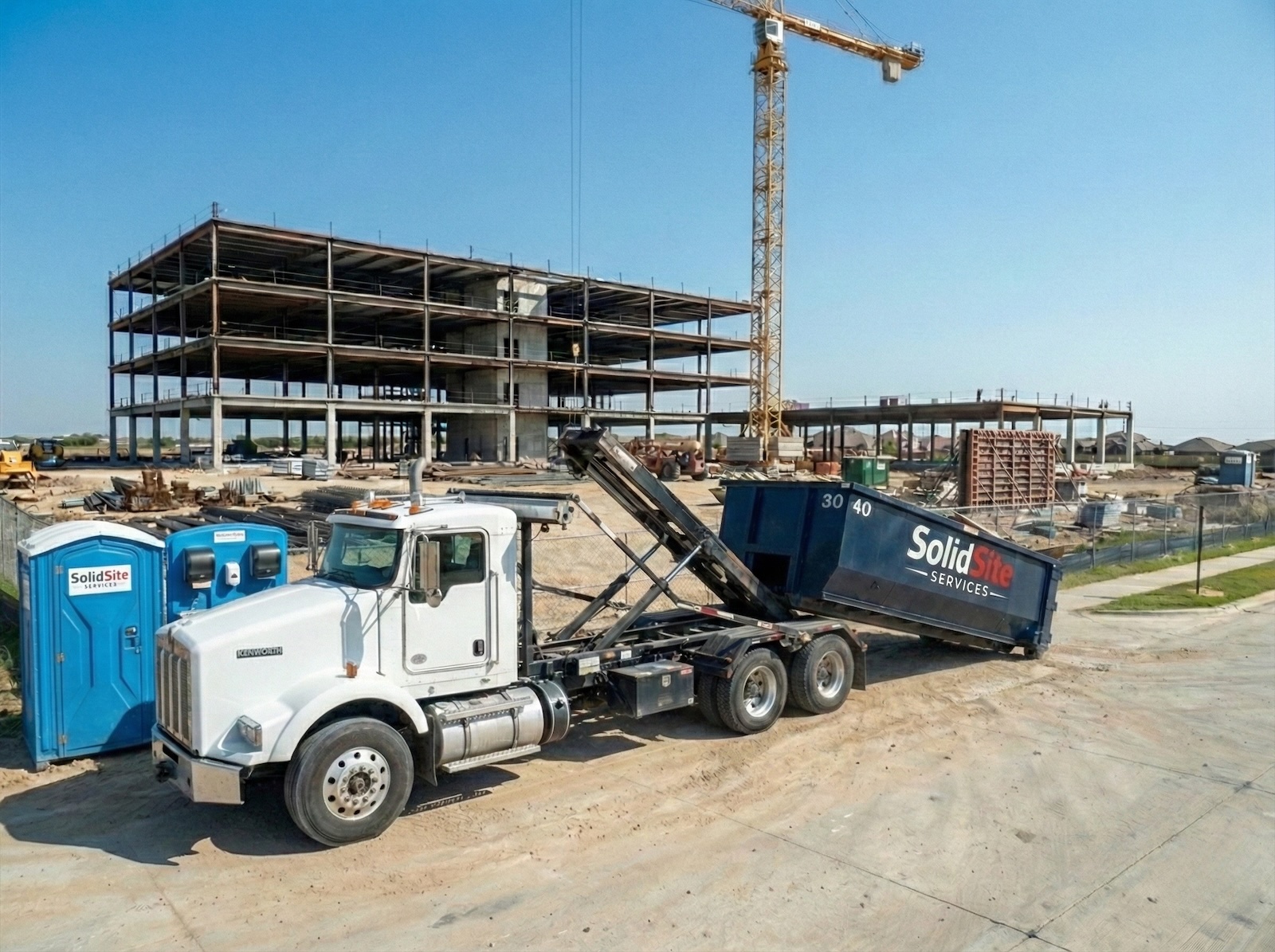 SolidSite-branded dumpster, restroom, excavator, and roll-off truck working a Houston commercial site